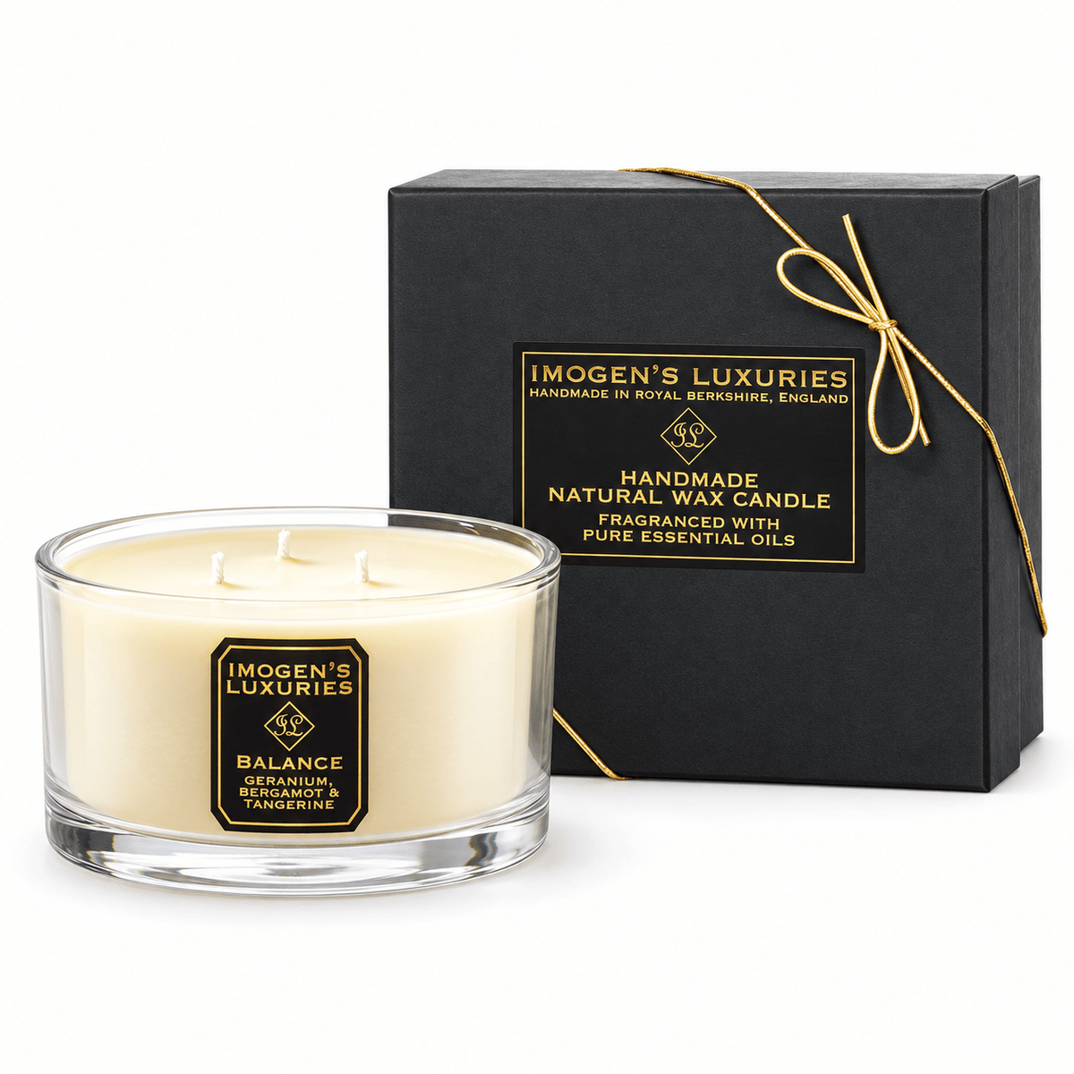 Cream coloured natural wax candle in glass container with 3 wicks. Candles is scented with Geranium, Bergamot & Tangerine Essential Oils. On the glass container is a black and gold label saying "Imogen's Luxuries" "Balance". The candle sits by a solid black and gold box with a black and gold label saying "Handmade Natural Wax Candle fragranced with pure essential oils. There is a fine gold bow across the box.