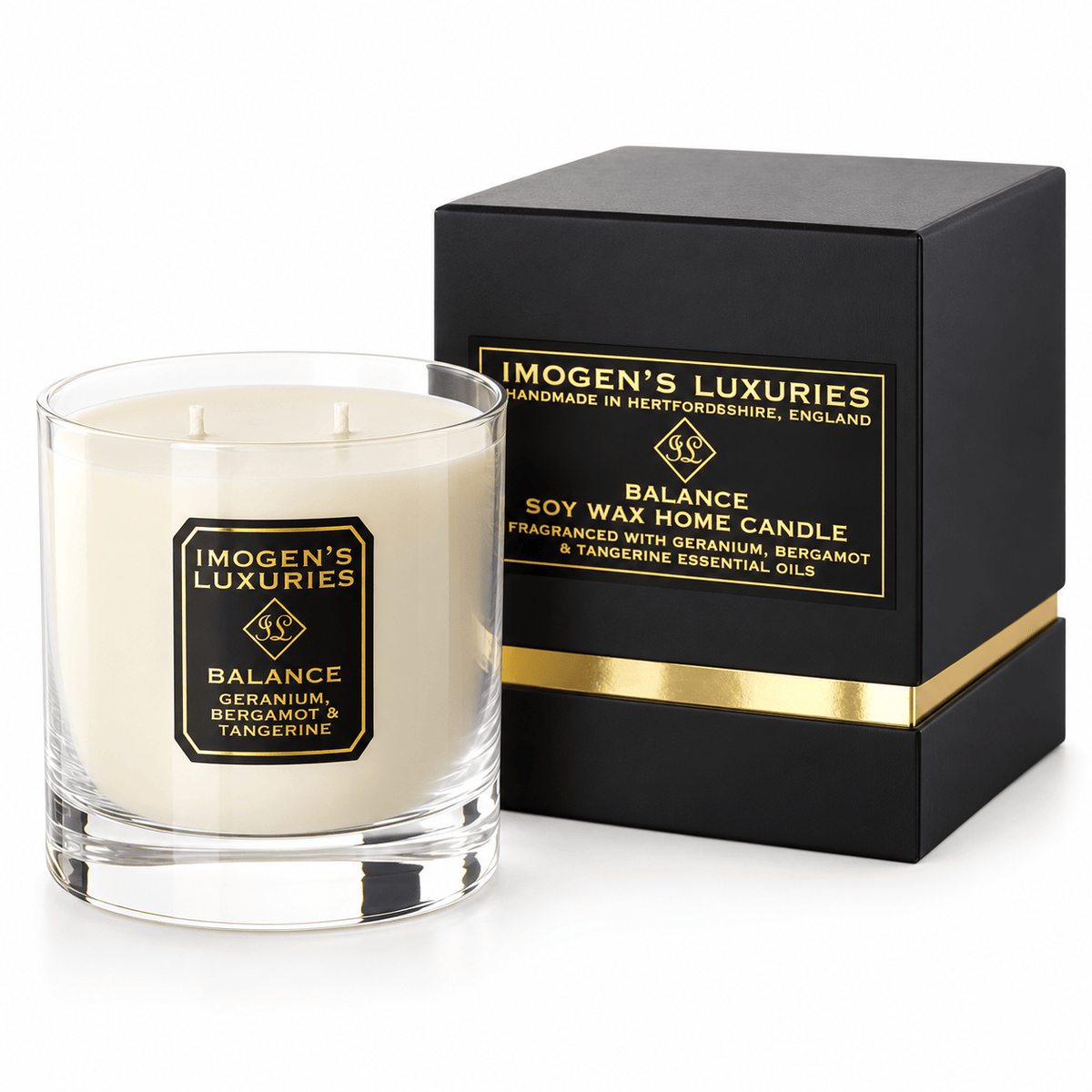 Cream coloured natural wax candle in glass container. Candles is scented with Geranium, Bergamot and Tangerine Essential Oils. On the glass container is a black and gold label saying "Imogen's Luxuries" "Balance". The candle sits by a solid black and gold shoulder box with a black and gold label saying "Handmade Natural Wax Candle fragranced with pure essential oils. Box has a gold elasticated bow on the top.
