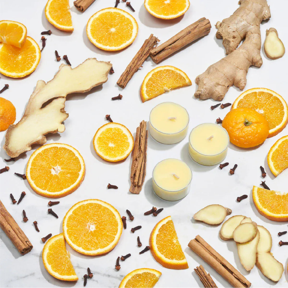 Imogen's Luxuries Christmas tea lights surrounded by orange sliced, cinnamon sticks, cloves and ginger pieces