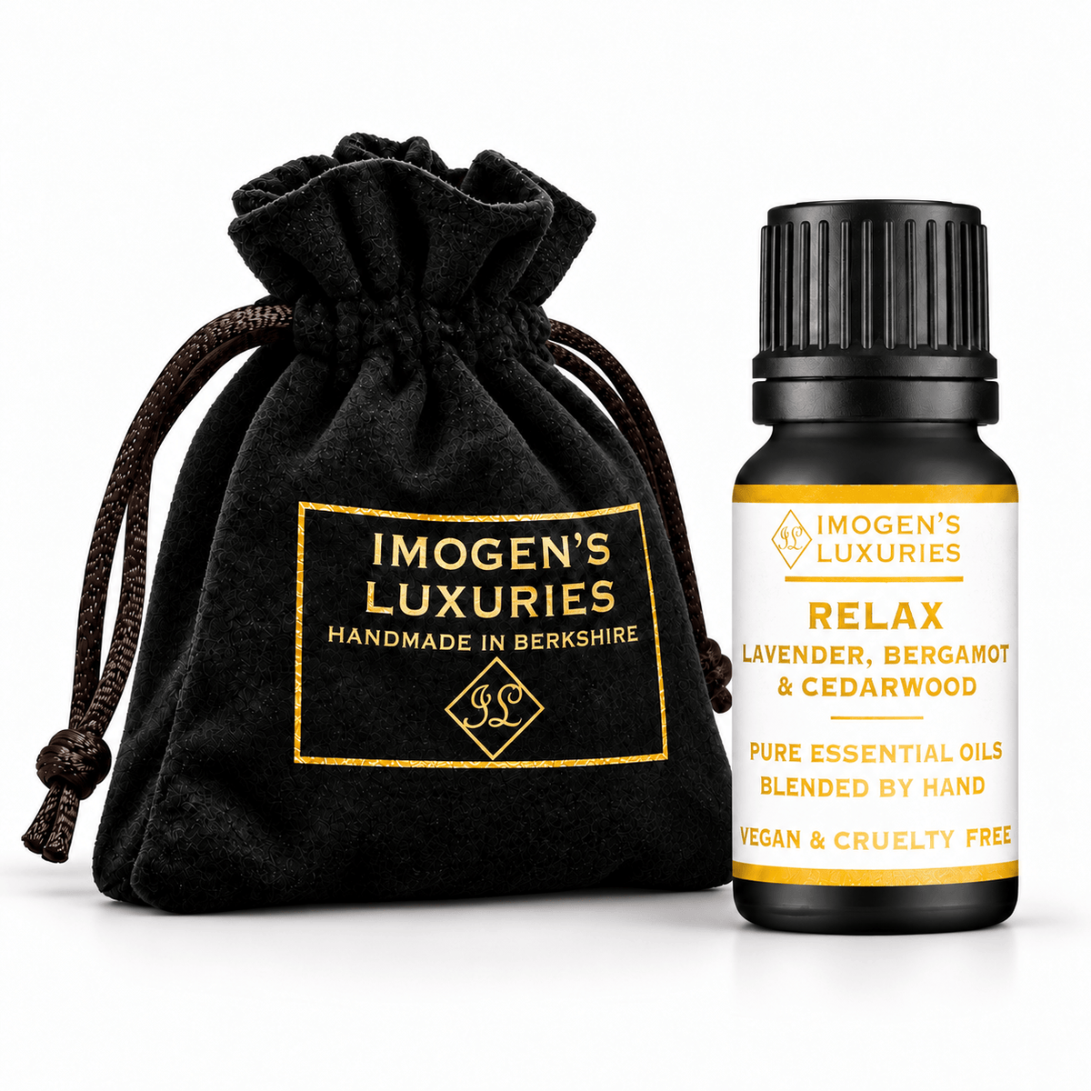 A 10ml black essential oil bottle with a black ribbed cap stands next to a black drawstring pouch. Both items are branded IMOGEN'S LUXURIES, with the pouch featuring gold lettering and the bottle featuring a white label with gold text. The label says " RELAX, LAVENDER, BERGAMOT & CEDARWOOD PURE ESSENTIAL OILS"