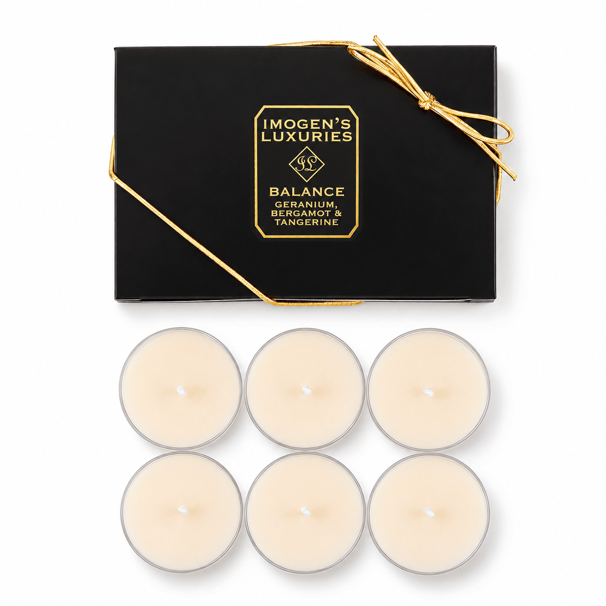 Six white tea light candles arranged below their black gift box with gold lettering and a gold bow, on a white background. The box reads 'IMOGEN'S LUXuRIES REVIVE, LEMONGRASS, GRAPEFRUIT & BASIL'.
