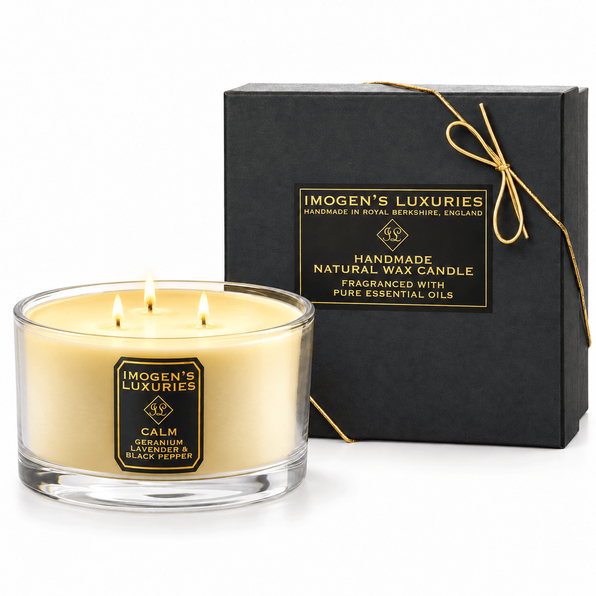 Cream coloured natural wax candle in glass container with 3 wicks all lit showing a neat flame. Candles is scented with  Geranium, Lavender & Black Pepper  Essential Oils. On the glass container is a black and gold label saying "Imogen's Luxuries" "Calm". The candle sits by a solid black and gold box with a black and gold label saying "Handmade Natural Wax Candle fragranced with pure essential oils. There is a fine gold bow across the box.