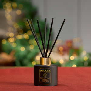 Christmas black reed diffuser is in a matt black 100ml bottle with 6 thick black reeds. Scented with Orange, Cinnamon, Clove and Ginger essential oils. A spiced Orange festive scent. Long lasting and highly scented. Handmade by Imogen's Luxuries, Berkshire. UK