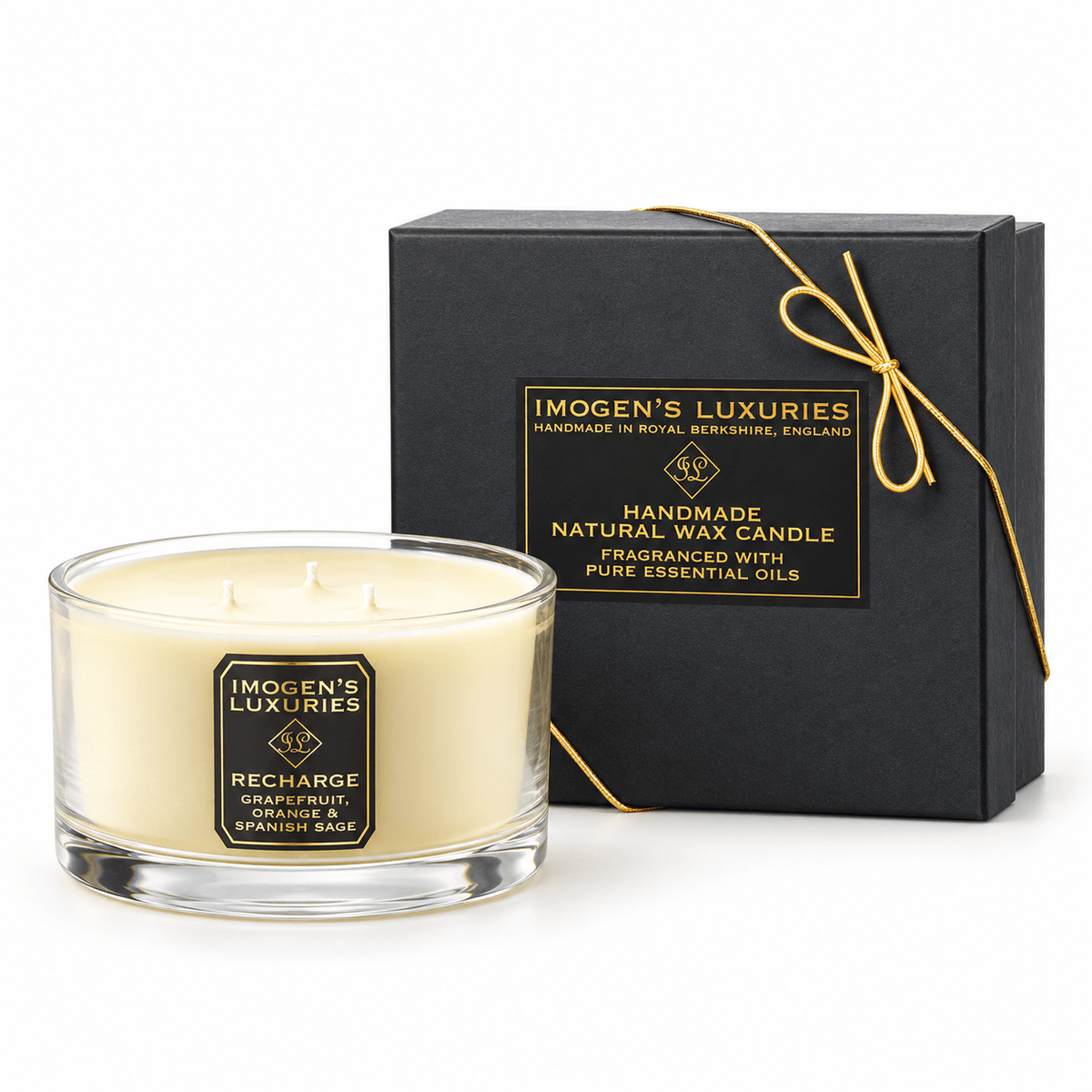 Cream coloured natural wax candle in glass container with 3 wicks. Candles is scented with Orange,Grapefruit & Spanish Sage Essential Oils. On the glass container is a black and gold label saying "Imogen's Luxuries" "Recharge". The candle sits by a solid black and gold box with a black and gold label saying "Handmade Natural Wax Candle fragranced with pure essential oils. There is a fine gold bow across the box.