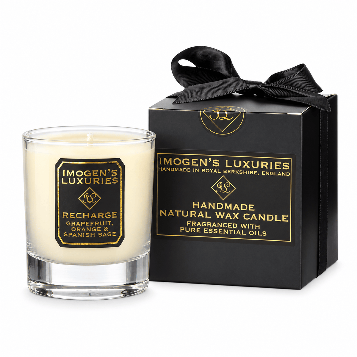 A glass container candle with natural cream coloured wax scented with Grapefruit, Orange & Spanish Sage Essential Oils. Candle has black and gold label and sits by a black and gold gift box with a stain bow.