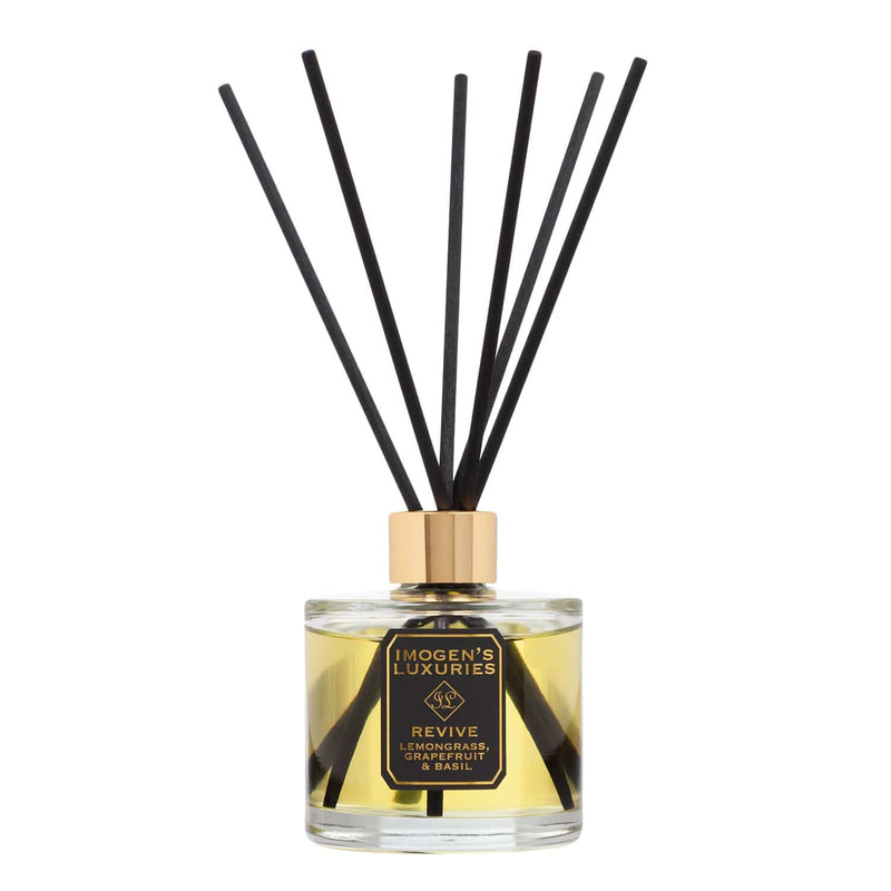 Revive luxury reed diffuser by Imogen's Luxuries, featuring a premium glass bottle with 100% pure essential oils of Lemongrass, Grapefruit & Basil. Hand-poured in Berkshire with high-performance black fibre reeds for long-lasting natural aromatherapy.